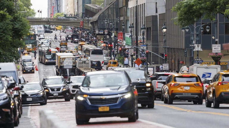Cars, buses, trucks and pedestrians navigate traffic on Second Avenue...