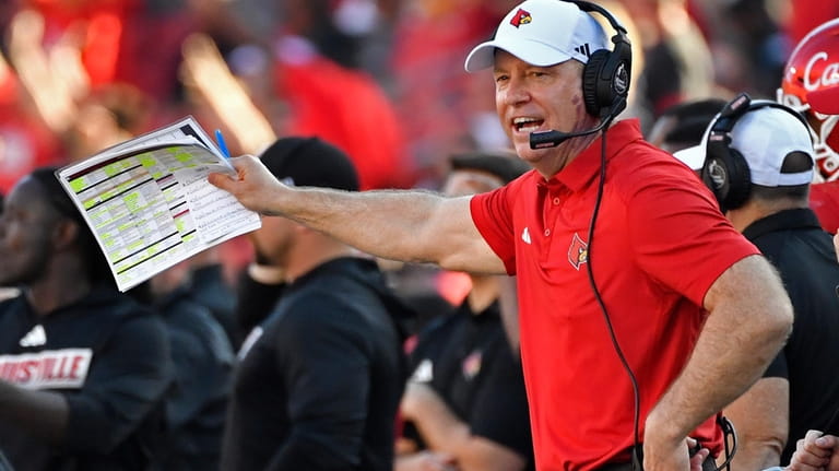 Louisville head coach Jeff Brohm shouts instructions to his team...