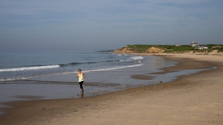 A woman runs on the beach at Ditch Plain Beach...