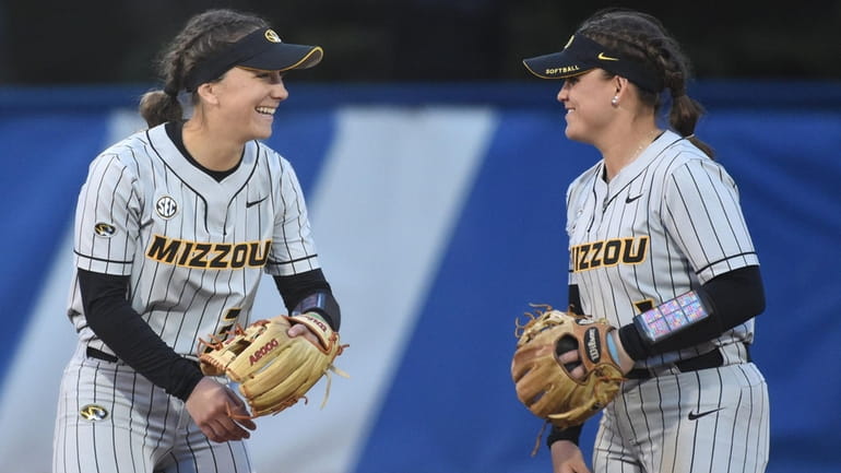 Jenna Laird, Missouri shortstop, left, and second basewoman Maddie Gallagher laugh...