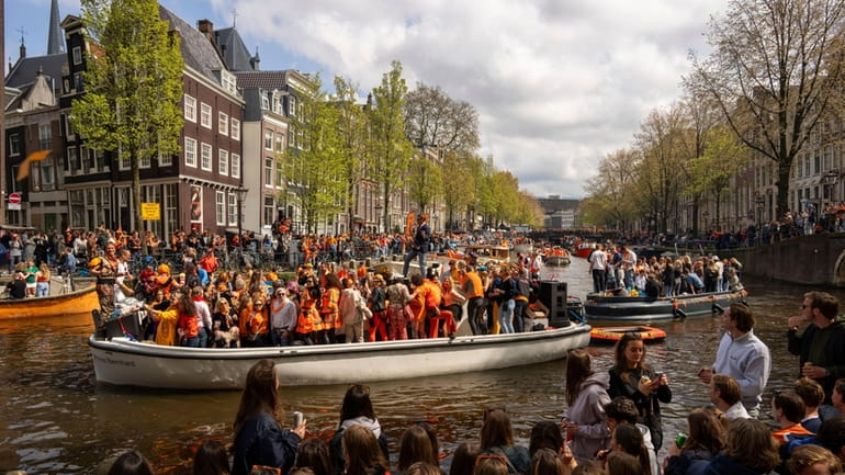 People dance on a boat during King's Day celebrations in...