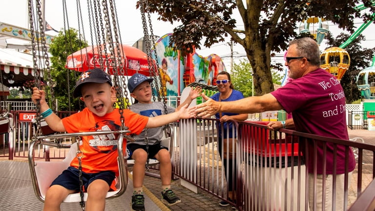 Kids ride amusement park rides at Adventureland on June 21,...