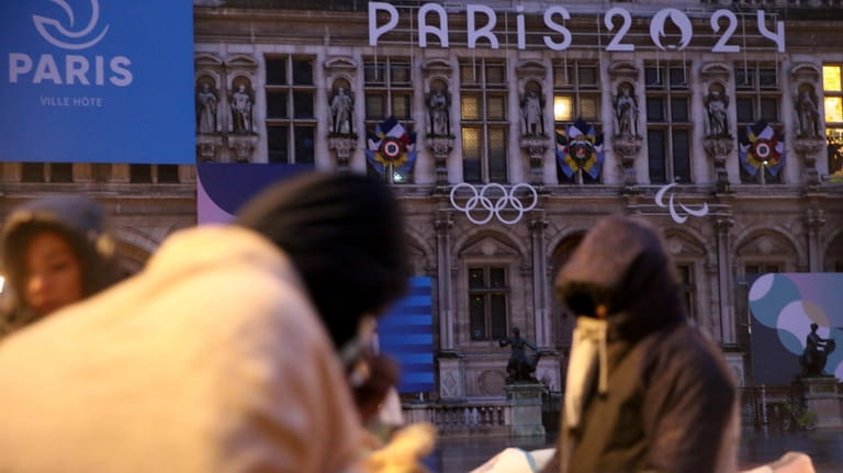 Migrants stand in front of the Paris City Hall, Wednesday,...