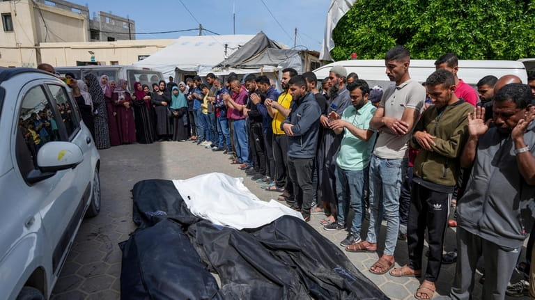 Mourners pray over the bodies of Palestinians who were killed...
