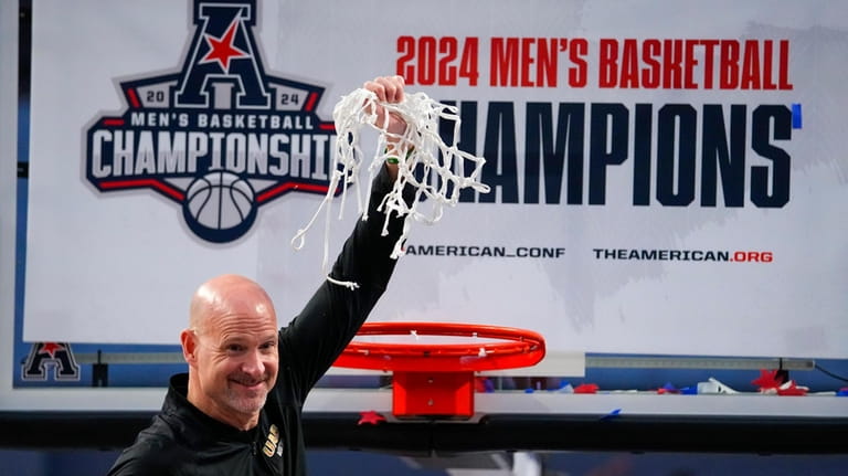 UAB head coach Andy Kennedy holds the net after cutting...