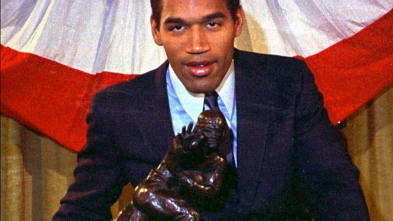 Southern Cal's O.J. Simpson poses with the Heisman Trophy at...
