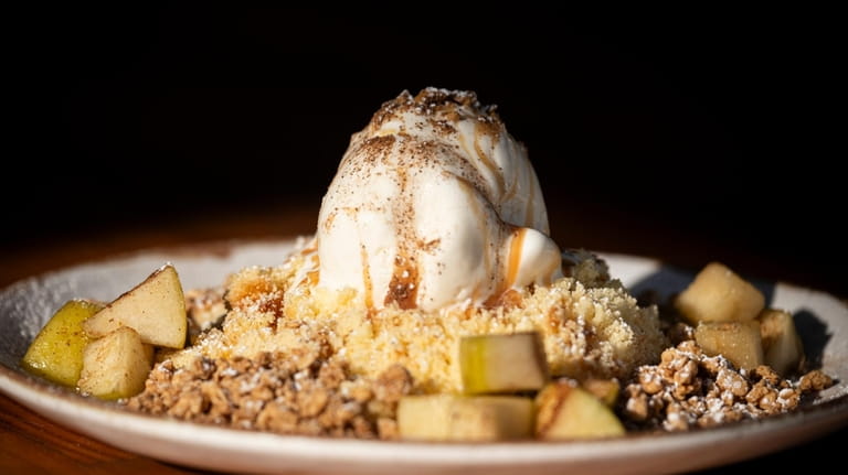 Apple Foster over crumbled cake with vanilla ice cream is...