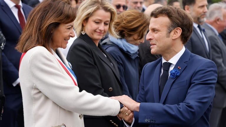 France's President Emmanuel Macron, right, shakes hands with Paris mayor,...