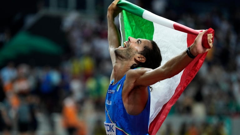 Gianmarco Tamberi, of Italy, celebrates after winning the gold medal...
